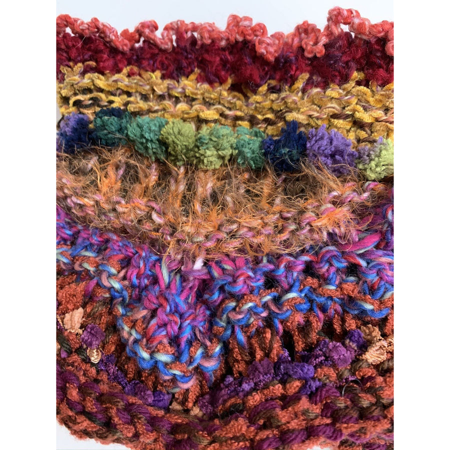 Detail of handknit scarf warmer in loads of colors and stitches with green accent (3.)